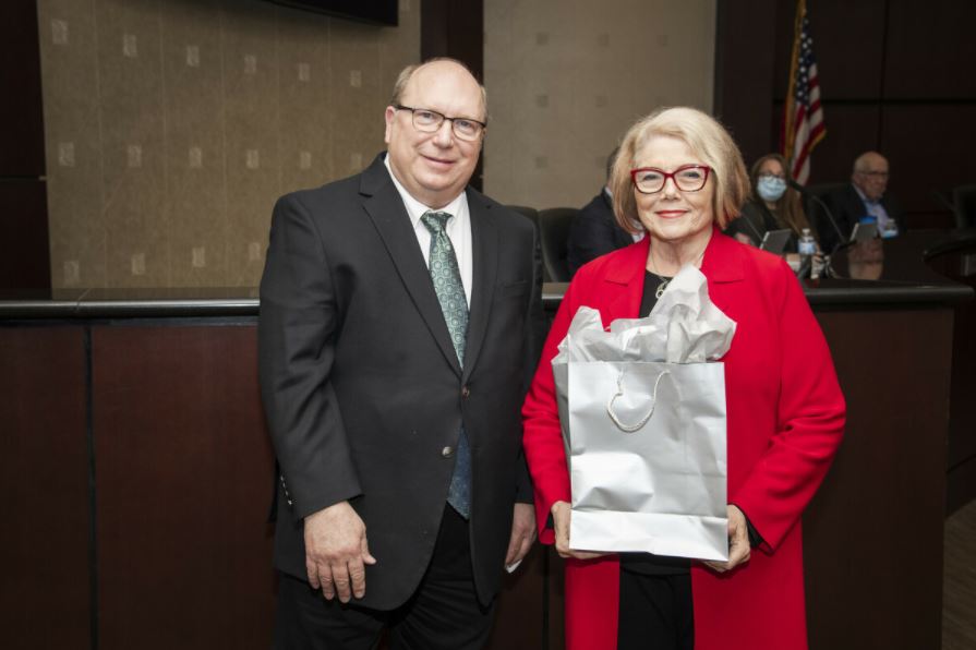 Collin College's Board of Trustees Andrew Hardin pictured here with Ann holding a silver gift bag. 