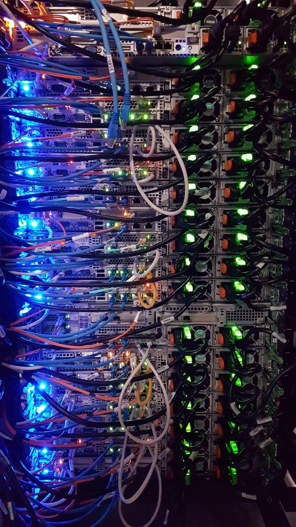 Stockphoto of server rack full of blue lights and cables.