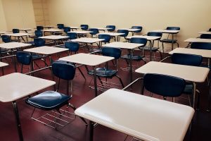 Stock photo of a college-style classroom with rows of empty student desks.