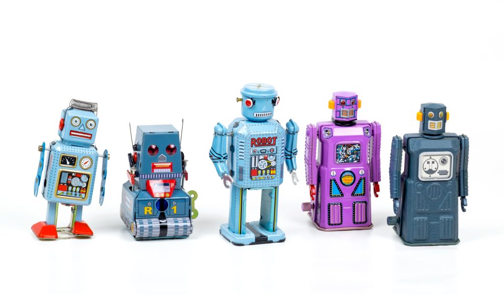Stock photo of a row of small colorful metal robot toys.