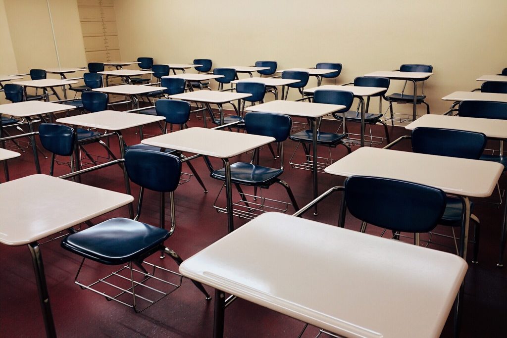 Stock photo of empty studnet desks in a classroom.