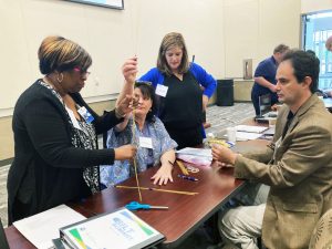 Faculty and administrator attendees at the BILT Summit workshop participate in the "marshmallow challenge" icebreaker team building exercise.