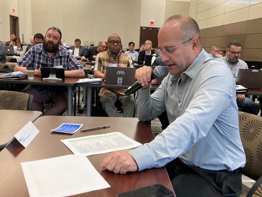 A BILT member references the KSA list as he gives remarks on the results of the May 2023 KSA vote - this meet was held in the Collin College conference center at the Frisco campus.